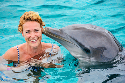 Une femme nage avec un dauphin
