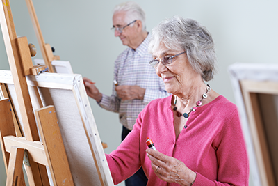 Des personnes âgées suivent un cours de peinture dans un atelier