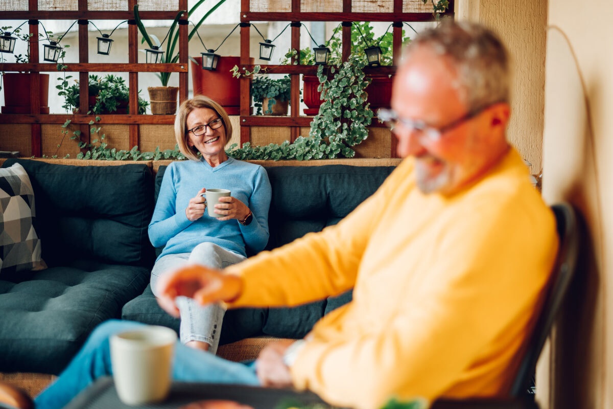 Ouder-echtpaar-drinkt-koffie-op-het-balkon-van-hun-huis